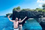 Massive natural rock archway over the turquoise ocean at Broken Beach, managed by Nusa Penida Transport Group